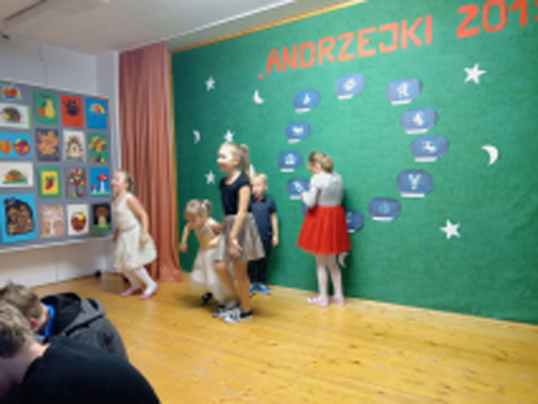 Uczniowie biorą udział w zabawach andrzejkowych, układają buty jeden za drugim, tańczą.