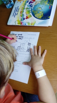 Uczeń rysuje na kartce