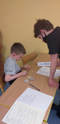 Chłopiec układa z zapałek wzór.