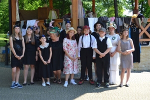 uczniowie przebrani w stroje z lat 20, 30,  tańczą, bawią się w stare gry, śpiewają, przedstawiają, oglądają teatrzyk