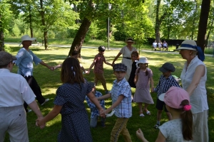 uczniowie przebrani w stroje z lat 20, 30,  tańczą, bawią się w stare gry, śpiewają, przedstawiają, oglądają teatrzyk