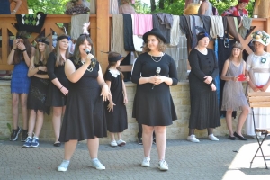 uczniowie przebrani w stroje z lat 20, 30,  tańczą, bawią się w stare gry, śpiewają, przedstawiają, oglądają teatrzyk