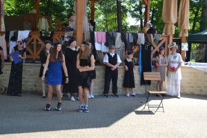uczniowie przebrani w stroje z lat 20, 30,  tańczą, bawią się w stare gry, śpiewają, przedstawiają, oglądają teatrzyk