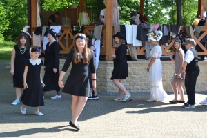 uczniowie przebrani w stroje z lat 20, 30,  tańczą, bawią się w stare gry, śpiewają, przedstawiają, oglądają teatrzyk