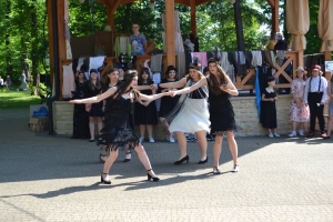 uczniowie przebrani w stroje z lat 20, 30,  tańczą, bawią się w stare gry, śpiewają, przedstawiają, oglądają teatrzyk