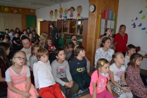 Uczniowie na scenie śpiewają pieśni. Koło sceny poczet sztandarowy, na scenie uczniowie przebrani w czarne stroje zaborców i  na biało za orła. Uczniowie składają znicze pod krzyżem.