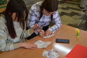 Uczniowie przy stolikach, rozwiązują krzyżówki, wykreślanki, rebusy.