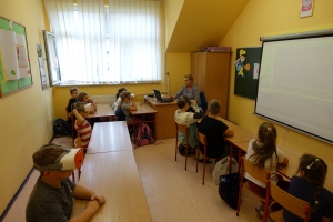 uczniowie przy stolikach w okularach vr