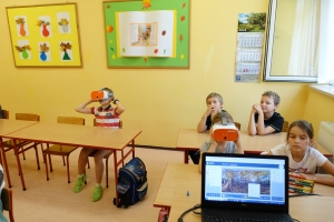 uczniowie przy stolikach w okularach vr