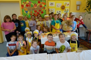 uczniowie ubrani w fartuszki jedzą chleb, oglądają film