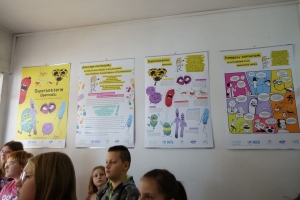 Uczniowie przy stolikach rysują, ogladają film.