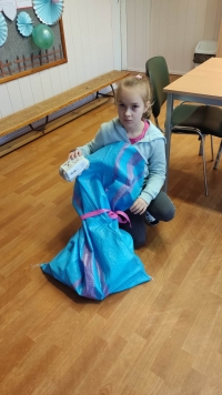 Uczniowie przy stolikach układają puzzle, rozwiązują rebusy. Ubierają się w ozdoby.