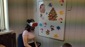 Uczniowie przy stolikach układają puzzle, rozwiązują rebusy. Ubierają się w ozdoby.