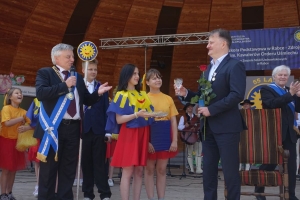 Występujący na scenie tańczą z pomponami, ze wstęgami. Na scenie dekoracja, pacynki Jacek i Agatka. Order Uśmiechu wręcza sekretarz Kapituły Orderu Uśmiechu i państwo Burcanowie.