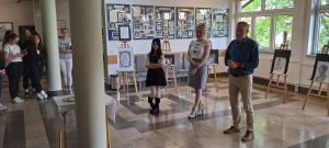 grupa 3 osób przegląda prace uczennicy